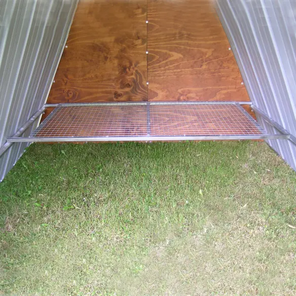 Interior of galvanized steel ground chicken coop with perch